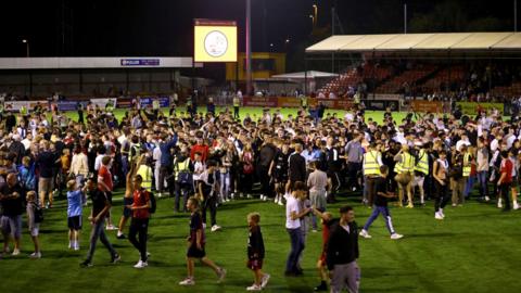 Crawley fans on the pitch following the win over Fulham