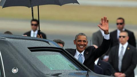 President Barack Obama (centre) waves as he gets in his limousine