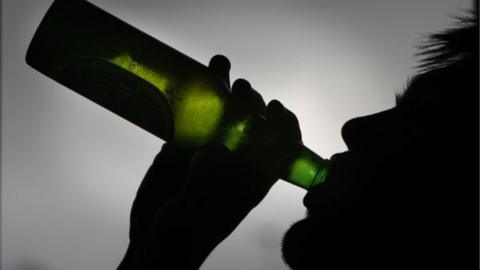 A man drinking beer from a bottle