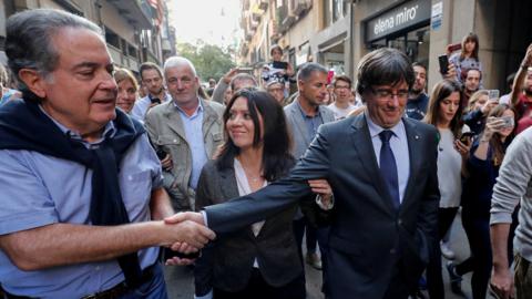 Carles Puigdemont (R) with wife in Girona greeting supporters