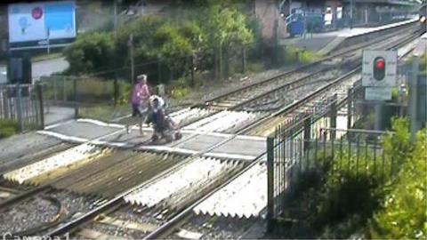 mother pushing pram at Wareham crossing on 11.5.09