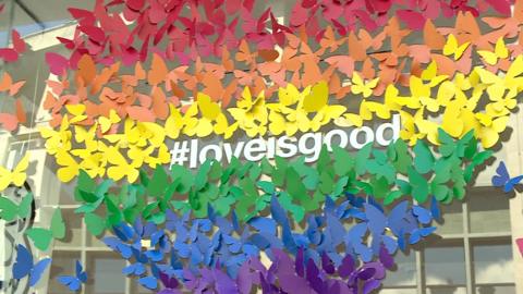 Pride inspired display with #loveisgood multi-coloured butterfly designed rainbow heart