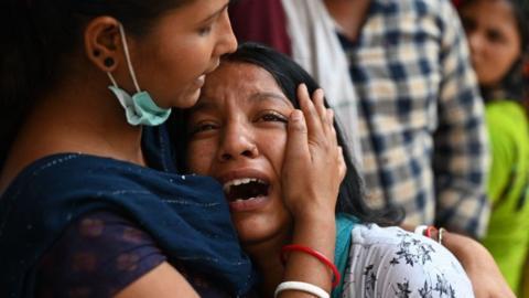 Relatives grieve outside the Sanjay Gandhi Memorial Hospital in Delhi on 14 May