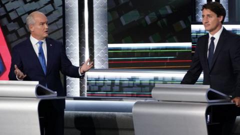 Conservative leader Erin O'Toole (L) turns to Canadian Prime Minister and Liberal leader Justin Trudeau during the federal election French-language leaders debate