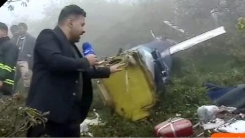 Reporter with blue microphone showing what he calls 'plane parts'