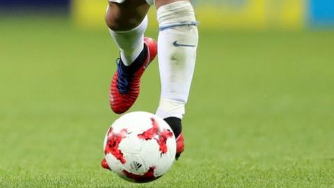 A Chilean player kicking the football