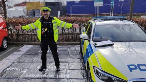 A police officer demonstrates the gap vehicles should leave