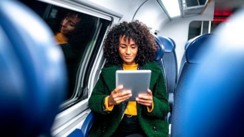 Woman using wi-fi device on train