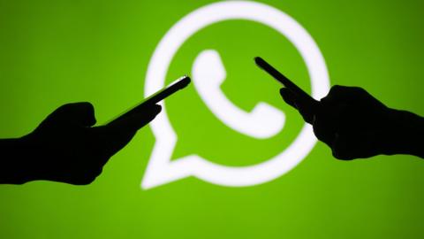 Two mobile phones and the WhatsApp logo