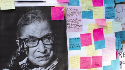 A photo and messages left in remembrance of the late Supreme Court Justice Ruth Bader Ginsburg are placed outside of the Harvard Law School library