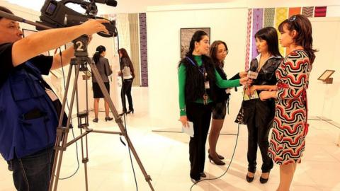 An Uzbek TV team films a design and fashion exhibition in Tashkent