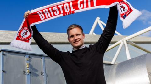 Liam Manning holds aloft a Bristol City scarf