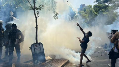 A protester throwing a gas canister in Colombo