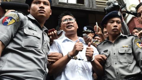 Myanmar journalist Wa Lone (C) is escorted by police after being sentenced by a court to jail in Yangon on September 3, 2018