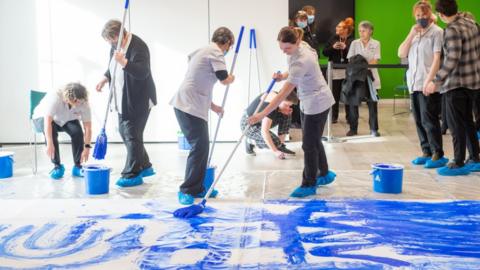 Cleaners creating artwork at Lancaster University