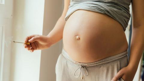 Pregnant woman with cigarette