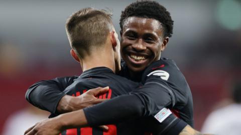 Bayer Leverkusen player Nathan Tella (right) celebrates a goal with team-mate Alejandro Grimaldo