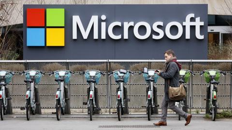 A pedestrian walks past the logo of the U.S. computer and micro-computing company, Microsoft on January 25, 2023 in Issy-les-Moulineaux, France