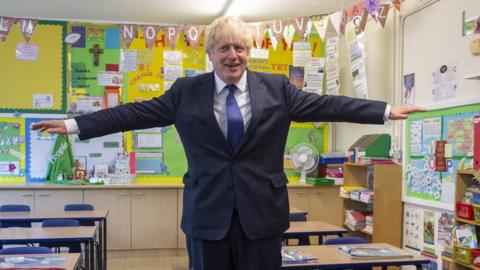 Boris Johnson demonstrates social distancing at a school in east London on 10 August