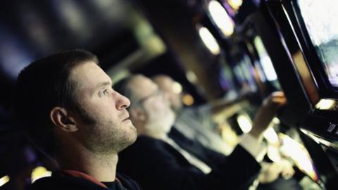 A young man gambling at a fixed odds terminal