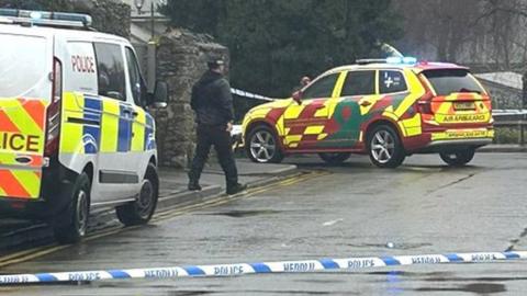 Police officers and police tape blocking a road in Llandaff, Cardiff