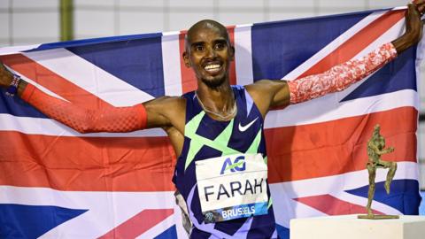 Mo Farah smiling with a Union Jack