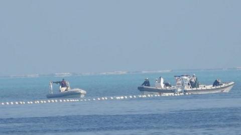 Chinese Coast Guard boats close to the floating barrier are pictured near the Scarborough Shoal