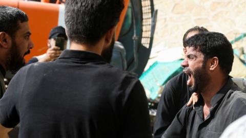 A man reacts as rescue workers search for survivors in the rubble of the collapsed Qattarat al-Imam Ali shrine in Iraq's Karbala region (21 August 2022)