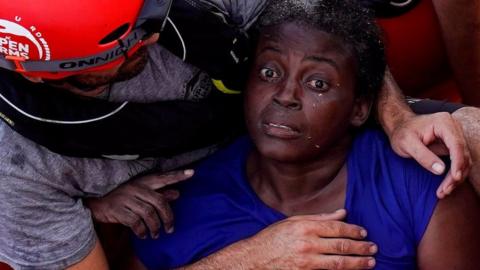 A crew member of NGO Proactiva Open Arms rescue boat embraces Josepha from Cameroon in central Mediterranean Sea