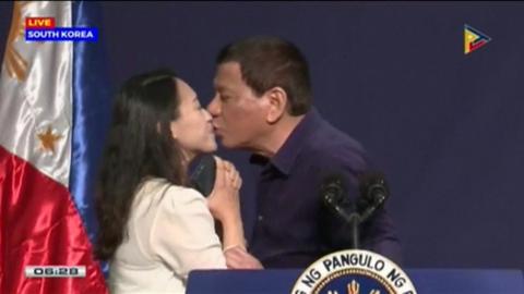 President Rodrigo Duterte kissing a woman on stage