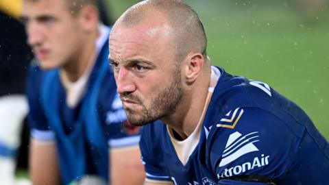 Josh Hodgson sits on the bench looking disappointed while with Parramatta