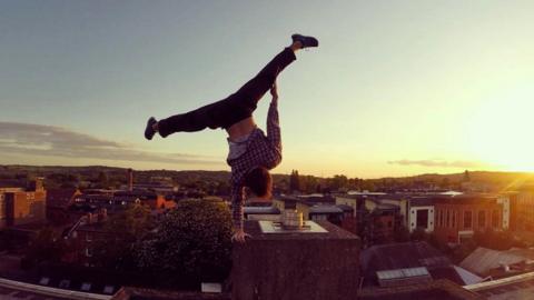 Man doing a one-arm handstand