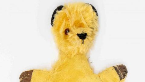 Auctioneer image of the yellow bear puppet.