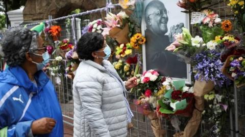 Mourners pay their respects to the late Archishop Desmond Tutu outside St Georges cathedral in Cape Town, South Africa, December 27. 2021