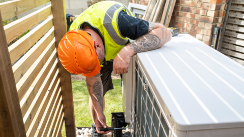 A man installing a heat pump in a garden