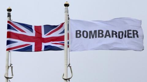 The Union Jack flutters alongside a Bombardier flag outside the Bombardier headquarters and factory in Belfast on 27 September 2017