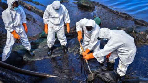 Volunteers collect leaked oil from the MV Wakashio bulk carrier that had run aground at the beach in Bois des Amourettes, Mauritius, on August 13, 2020