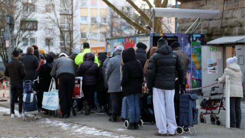 People wait outside the food distribution centre at the Tafel in Essen, Germany, 26 February 2018