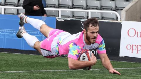 Iwan Stephens dives over the try line to score for Newcastle