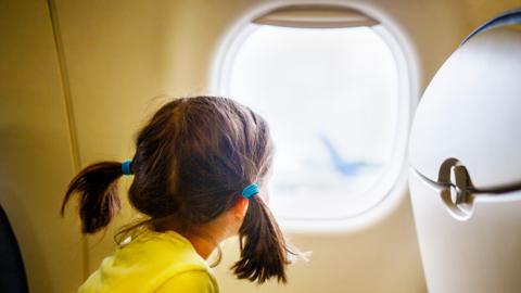 Child looking out of an aircraft window