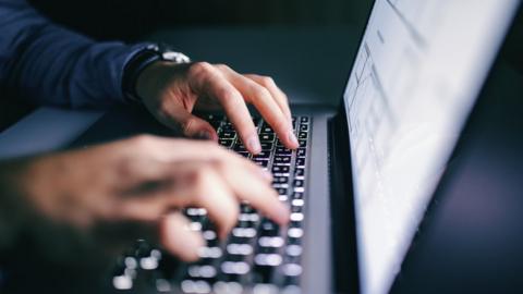 Close up of hands typing on laptop