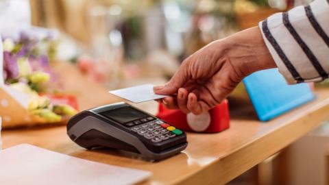 A woman using a card machine to make a payment