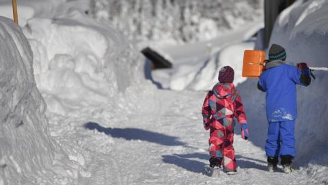 Children walk along a snow covered road in Gerold, Germany, 11 January 2019