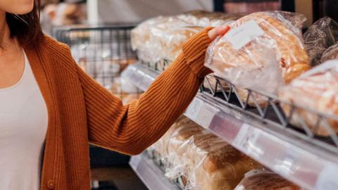 Stock image of a woman buying bread