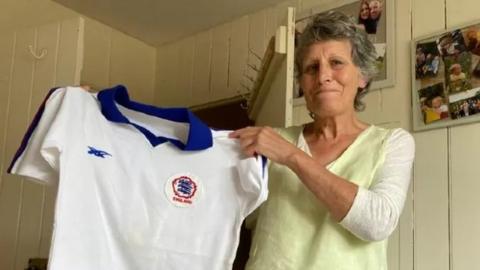 Eileen Foreman holding her Lioness shirt