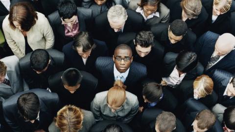 A group of people with a black man in the middle