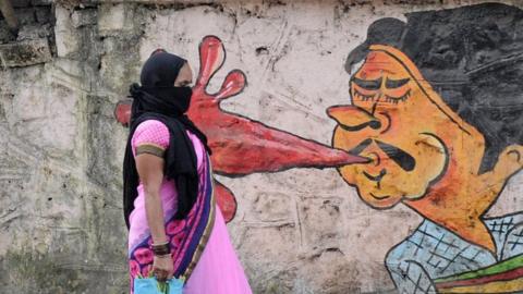 A woman walks past a graffiti in Mumbai. Municipal corporation is creating awareness about the dangers of spitting in public places through graffiti.