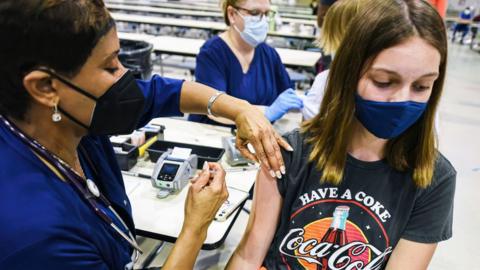 A healthworker vaccinates a girl in Florida, August 2021