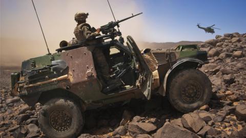 A file photo from 21 March 2013 shows a French soldier standing guard in an armoured vehicle in northern Mali