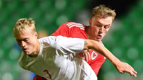 Tobias Bech of Denmark is tackled by Eli King of Wales